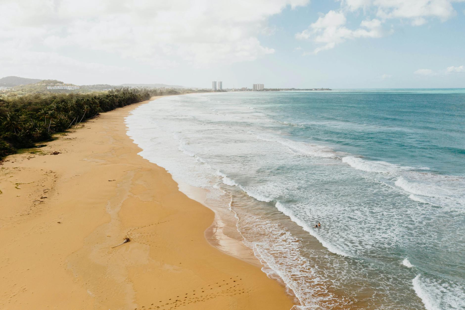 Golden sandy beach in Puerto Rico with gentle turquoise waves ideal for tropical vacation