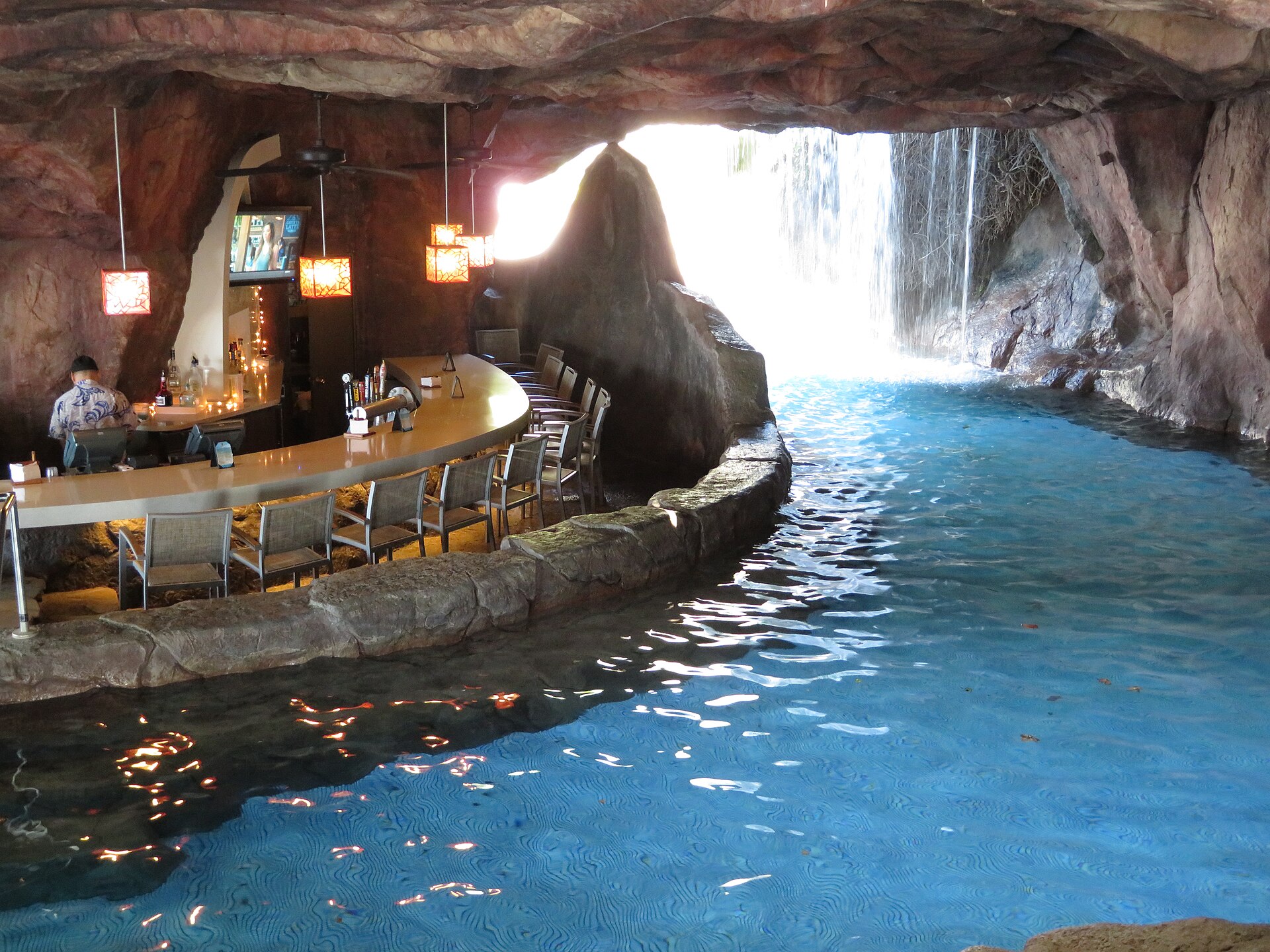 A cave-style grotto bar curving along a blue pool with a waterfall at the Hyatt resort in Ka'anapali, Maui.