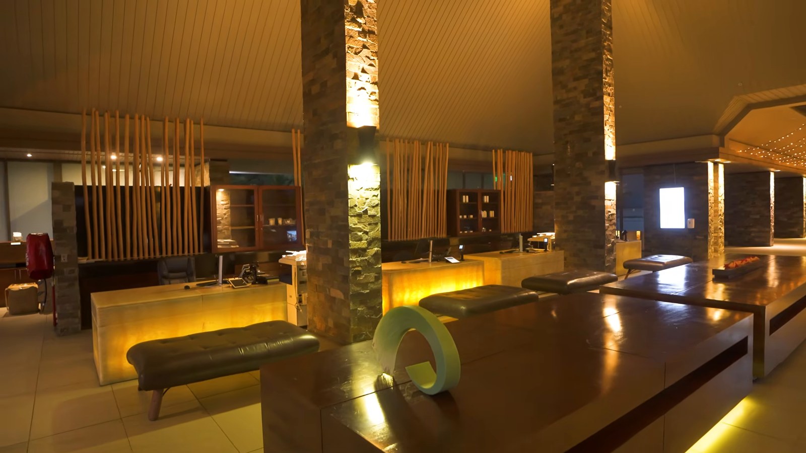 The open-air lobby and check-in area of InterContinental Fiji Golf Resort & Spa at night, with wood-slat screens and stone columns.