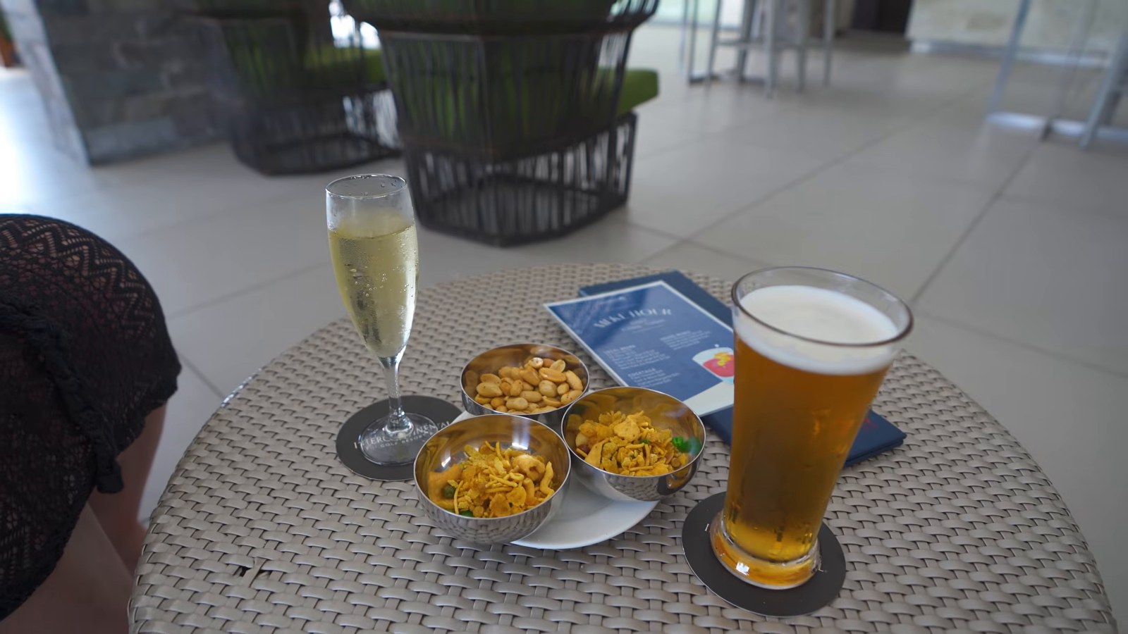 Two welcome drinks and bowls of snacks on an outdoor table with an InterContinental-branded coaster.